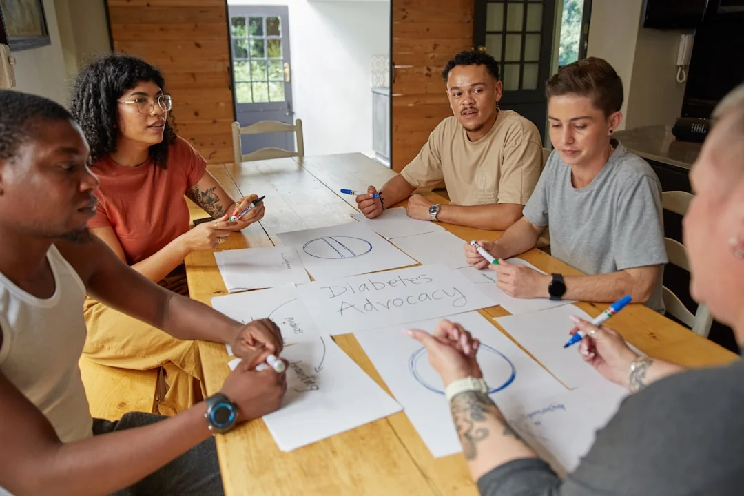Un team eterogeneo che lavora insieme su strategie di marketing digitale a una scrivania, usando laptop e tablet.